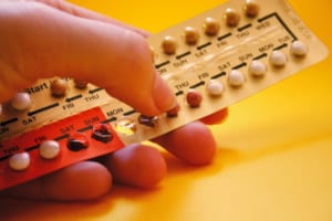 picture of woman's hand holding birth control pills