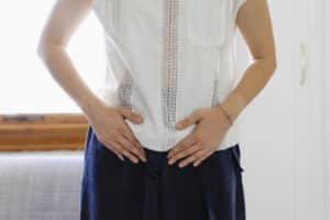 Woman with hands near pelvis | Uterine Fibroids